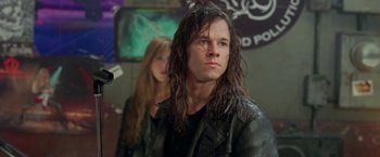Movie still from “Rock Star” (2001), directed by Stephen Herek – A man and a woman are standing in front of a wall; Close Up shot, Over the shoulder angle