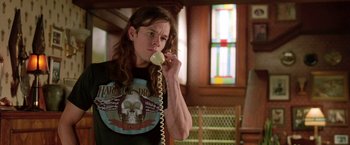 Movie still from “Rock Star” (2001), directed by Stephen Herek – A person holding a phone up to their ear; Medium shot, Low angle