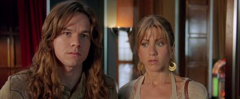 Movie still from “Rock Star” (2001), directed by Stephen Herek – A man and a woman standing next to each other in a room; Close Up shot, High angle