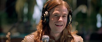 Movie still from “Rock Star” (2001), directed by Stephen Herek – A man with long brown hair wearing headphones; Close Up shot, High angle