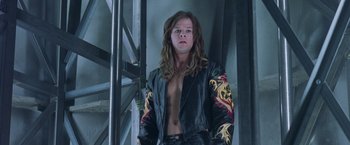 Movie still from “Rock Star” (2001), directed by Stephen Herek – A man with long hair and a leather jacket; Medium shot, Low angle