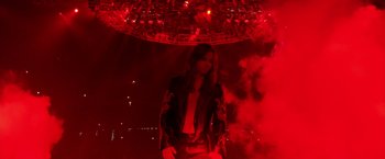 Movie still from “Rock Star” (2001), directed by Stephen Herek – A man in a leather jacket standing under a red light; Wide shot, High angle