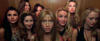 Movie still from “Rock Star” (2001), directed by Stephen Herek – A group of women standing next to each other in front of a wall; Close Up shot, Overhead angle