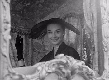 Movie still from “Roman Holiday” (1953), directed by William Wyler – An old photo of a woman with a hat in front of a mirror; Close Up shot, Over the shoulder angle