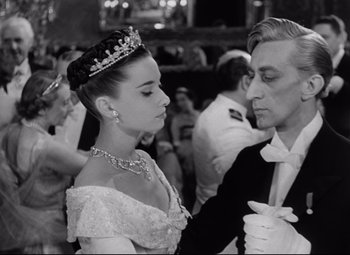 Movie still from “Roman Holiday” (1953), directed by William Wyler – A man and a woman in formal wear at a party; Close Up shot, Low angle