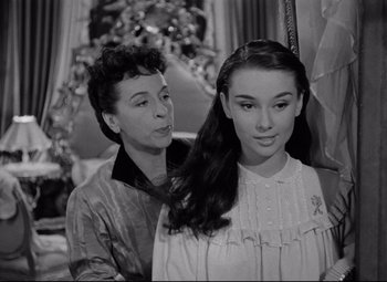 Movie still from “Roman Holiday” (1953), directed by William Wyler – An older woman and a younger woman are posing for a picture; Close Up shot, Over the shoulder angle