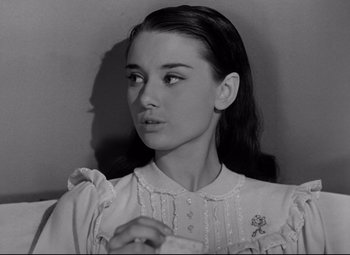 Movie still from “Roman Holiday” (1953), directed by William Wyler – Black and white photograph of a young woman looking at the camera; Close Up shot, Low angle