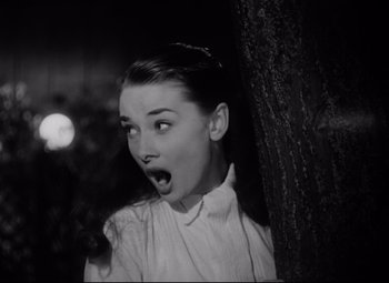 Movie still from “Roman Holiday” (1953), directed by William Wyler – A black - and - white photo of a woman with her mouth wide open; Close Up shot, Low angle