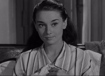 Movie still from “Roman Holiday” (1953), directed by William Wyler – A black - and - white photo of a woman in a striped shirt; Close Up shot, Over the shoulder angle