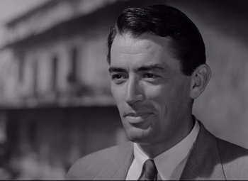 Movie still from “Roman Holiday” (1953), directed by William Wyler – A man wearing a suit and tie in a black and white photo; Close Up shot, Low angle