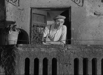 Movie still from “Roman Holiday” (1953), directed by William Wyler – An old man looking out of a window; Medium shot, Low angle