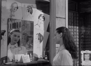 Movie still from “Roman Holiday” (1953), directed by William Wyler – A black and white photo of a woman looking in a mirror; Medium shot, Over the shoulder angle