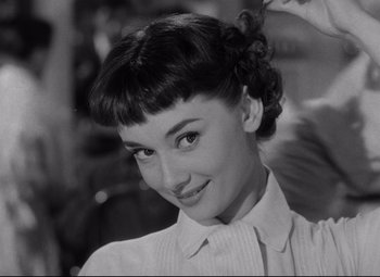 Movie still from “Roman Holiday” (1953), directed by William Wyler – A black and white photo of a woman with short hair; Close Up shot, Over the shoulder angle