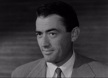 Movie still from “Roman Holiday” (1953), directed by William Wyler – A black and white photo of a man in a suit; Close Up shot, Low angle