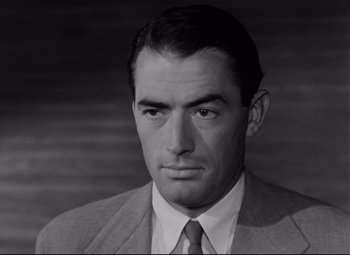 Movie still from “Roman Holiday” (1953), directed by William Wyler – Black and white photograph of a man wearing a suit; Close Up shot, Low angle