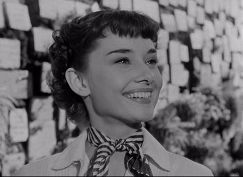 Movie still from “Roman Holiday” (1953), directed by William Wyler – An old black and white photo of a woman smiling; Close Up shot, Low angle