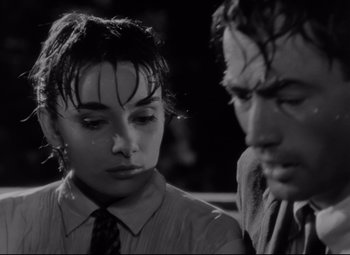 Movie still from “Roman Holiday” (1953), directed by William Wyler – A man and a woman sitting next to each other in front of each other; Close Up shot, High angle