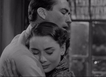 Movie still from “Roman Holiday” (1953), directed by William Wyler – A man and a woman embracing each other; Close Up shot, Low angle