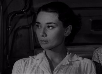 Movie still from “Roman Holiday” (1953), directed by William Wyler – Black and white photograph of a woman looking at the camera; Close Up shot, High angle