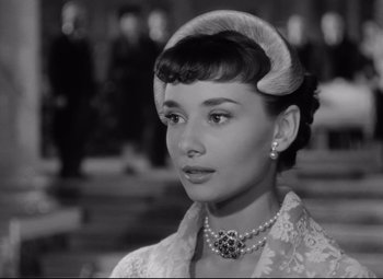 Movie still from “Roman Holiday” (1953), directed by William Wyler – A black - and - white photo of a woman in a dress; Close Up shot, Over the shoulder angle