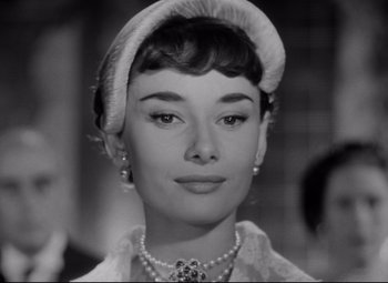 Movie still from “Roman Holiday” (1953), directed by William Wyler – A black - and - white photo of a woman in a hat; Close Up shot, Low angle