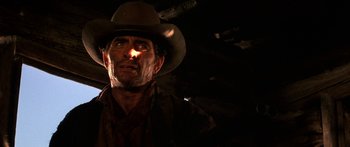 Movie still from “Romancing the Stone” (1984), directed by Robert Zemeckis – A man wearing a cowboy hat in the dark; Close Up shot, Low angle