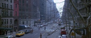 Movie still from “Romancing the Stone” (1984), directed by Robert Zemeckis – A city street with cars and people crossing the street; Extreme Wide shot, High angle