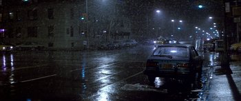 Movie still from “Romancing the Stone” (1984), directed by Robert Zemeckis – Cars parked on a street in the rain at night; Extreme Wide shot, High angle