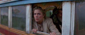 Movie still from “Romancing the Stone” (1984), directed by Robert Zemeckis – A woman looking out of a window in a bus; Close Up shot, Low angle