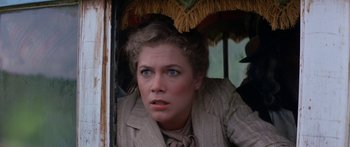 Movie still from “Romancing the Stone” (1984), directed by Robert Zemeckis – A person wearing a suit and hat; Close Up shot, Over the shoulder angle