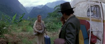 Movie still from “Romancing the Stone” (1984), directed by Robert Zemeckis – A man and a woman standing in a field; Wide shot, Over the shoulder angle