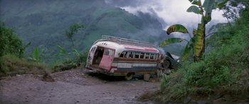 Movie still from “Romancing the Stone” (1984), directed by Robert Zemeckis – An old bus and a car in the middle of a dirt road; Extreme Wide shot, Low angle