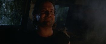 Movie still from “Romancing the Stone” (1984), directed by Robert Zemeckis – A person with long hair smiling; Close Up shot, Low angle