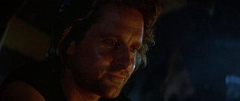 Movie still from “Romancing the Stone” (1984), directed by Robert Zemeckis – A man's face in the dark; Close Up shot, Over the shoulder angle