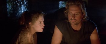 Movie still from “Romancing the Stone” (1984), directed by Robert Zemeckis – A man and a woman sitting next to each other in a dark room; Close Up shot, Over the shoulder angle