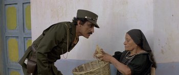 Movie still from “Romancing the Stone” (1984), directed by Robert Zemeckis – A man in a military uniform looking at a woman in a military uniform; Medium shot, Over the shoulder angle