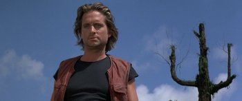 Movie still from “Romancing the Stone” (1984), directed by Robert Zemeckis – A person with long hair wearing a leather vest; Close Up shot, Low angle