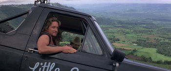 Movie still from “Romancing the Stone” (1984), directed by Robert Zemeckis – A man and a woman sitting in the driver's seat of a truck; Medium shot, Low angle