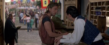 Movie still from “Romancing the Stone” (1984), directed by Robert Zemeckis – Two men are talking in the street; Medium shot, Over the shoulder angle