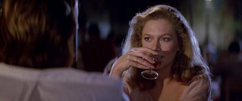 Movie still from “Romancing the Stone” (1984), directed by Robert Zemeckis – A beautiful woman drinking a glass of wine; Close Up shot, Over the shoulder angle
