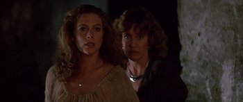 Movie still from “Romancing the Stone” (1984), directed by Robert Zemeckis – Two women standing next to each other in the dark; Close Up shot, Low angle