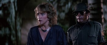 Movie still from “Romancing the Stone” (1984), directed by Robert Zemeckis – A person wearing a black shirt; Close Up shot, Over the shoulder angle