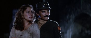 Movie still from “Romancing the Stone” (1984), directed by Robert Zemeckis – A man and a woman standing next to each other; Close Up shot, Low angle