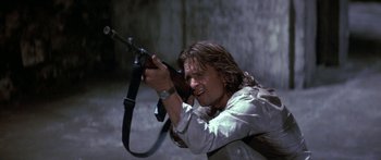 Movie still from “Romancing the Stone” (1984), directed by Robert Zemeckis – A man holding a gun while standing in the dark; Close Up shot, Low angle