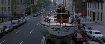Movie still from “Romancing the Stone” (1984), directed by Robert Zemeckis – Two people on the bow of a boat on a city street; Wide shot, High angle