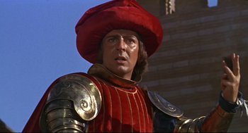 Movie still from “Romeo and Juliet” (1968), directed by Franco Zeffirelli – A person wearing armor and a red hat; Close Up shot, Low angle