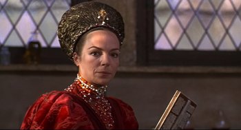 Movie still from “Romeo and Juliet” (1968), directed by Franco Zeffirelli – A woman in a red dress and a gold hat; Close Up shot, Over the shoulder angle