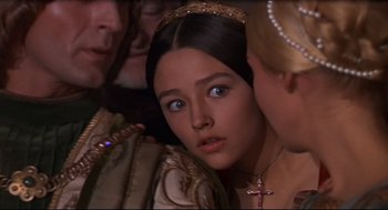 Movie still from “Romeo and Juliet” (1968), directed by Franco Zeffirelli – A young woman in medieval garb looking into the distance; Close Up shot, Over the shoulder angle