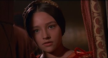 Movie still from “Romeo and Juliet” (1968), directed by Franco Zeffirelli – A person wearing a red dress; Close Up shot, Over the shoulder angle