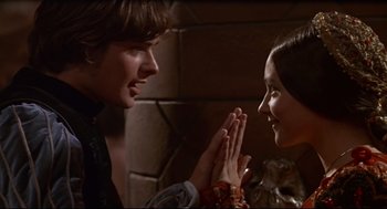 Movie still from “Romeo and Juliet” (1968), directed by Franco Zeffirelli – A man and a woman clasping hands in front of a brick wall; Close Up shot, High angle